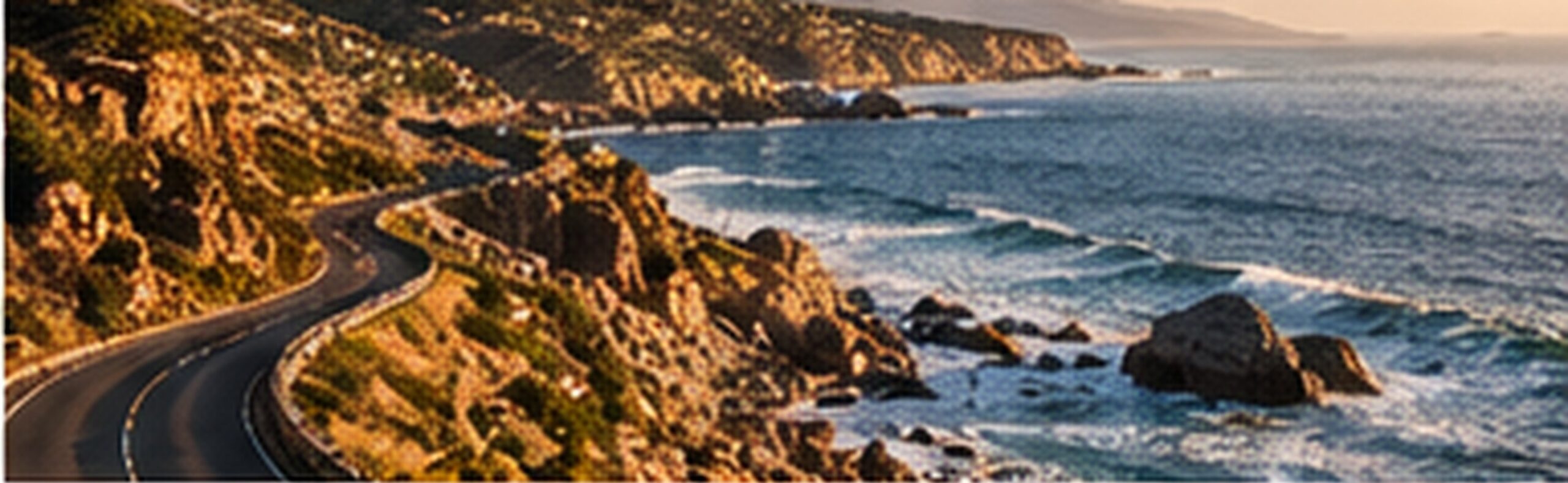 A coastal road winding above a rocky shoreline and breaking waves