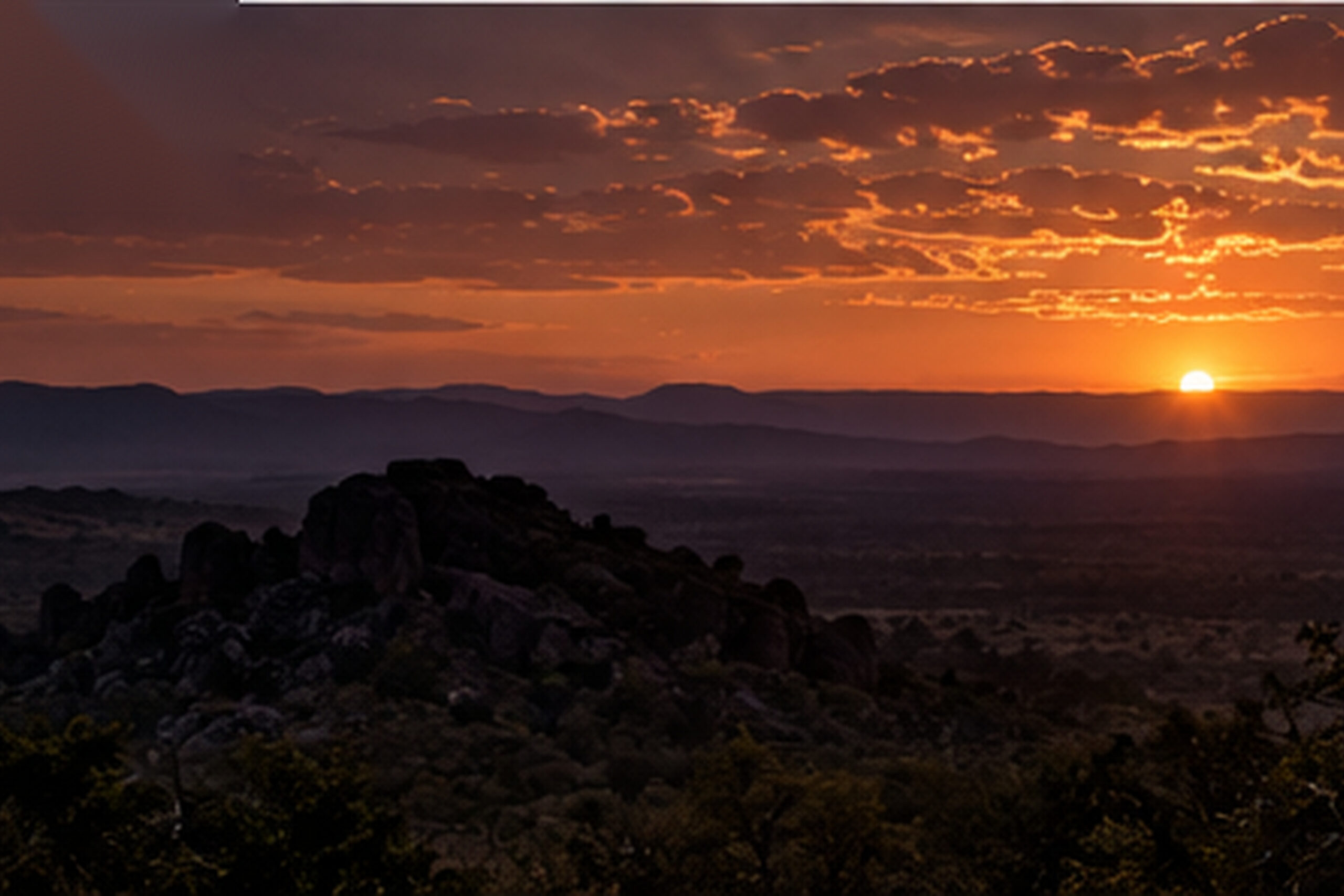 Sunset over rocky koppies and bushveld hills