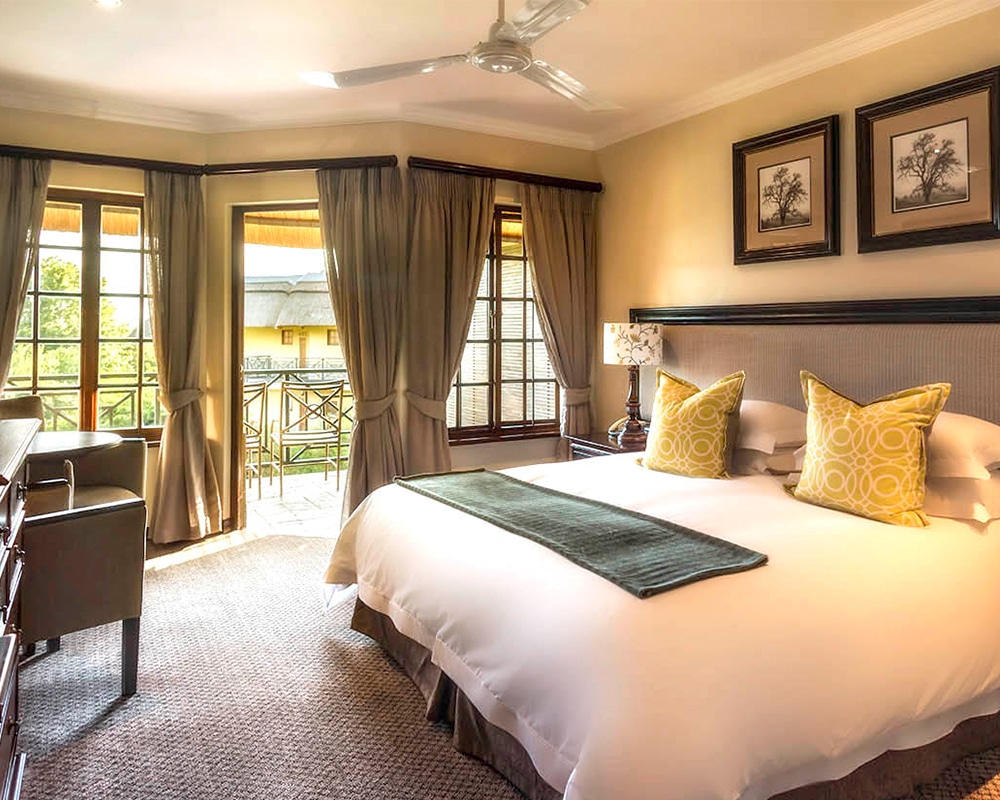 Champagne Sports Resort – Family Room Main Bedroom With Seating Area And Balcony With A View Of The Hotel