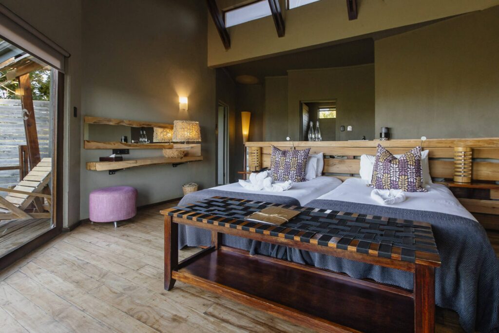 Twin safari room with wooden finishes, private deck, and modern decor at Rhino Ridge Safari Lodge.