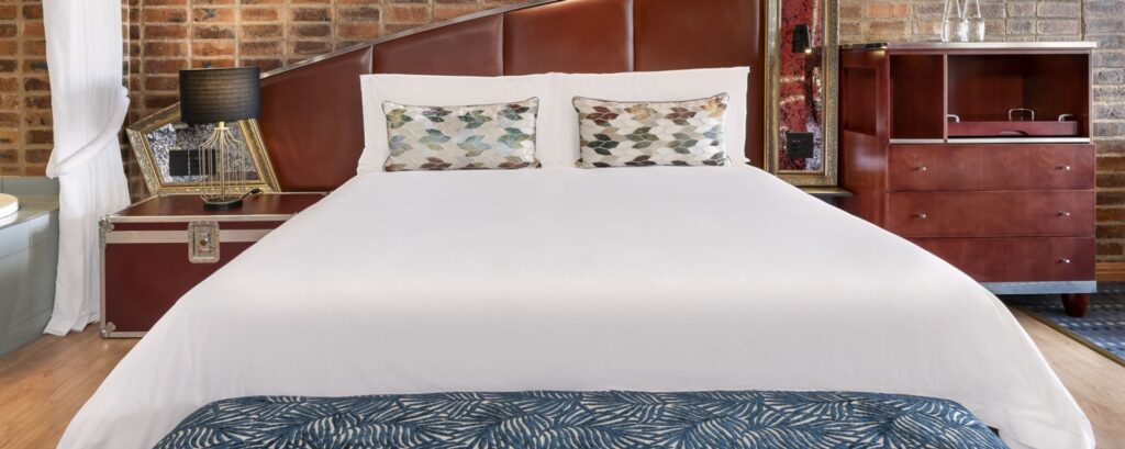 African Pride Melrose Arch, Autograph Collection – Room with King bed and brown cabinet