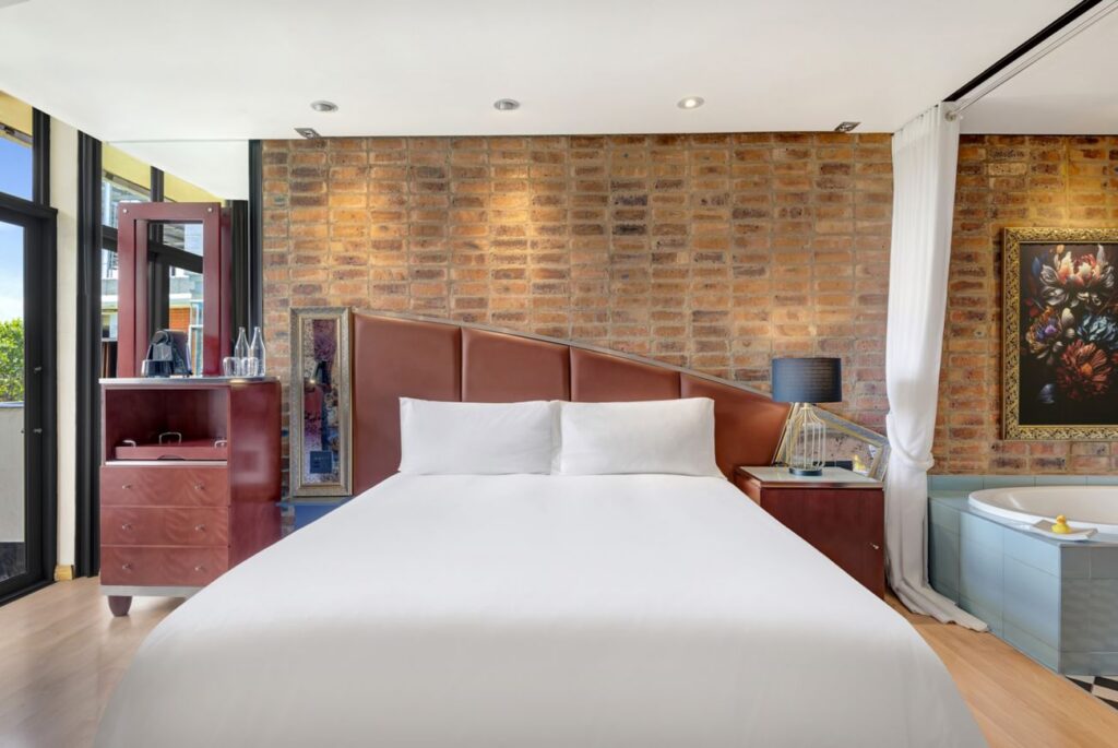 African Pride Melrose Arch, Autograph Collection – King bed, dresser, and a bathtub
