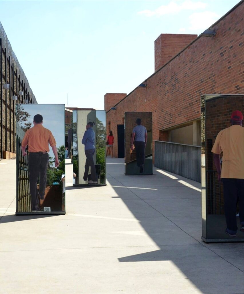 Visitors walking between the entrance pillars of the Apartheid Museum, Johannesburg