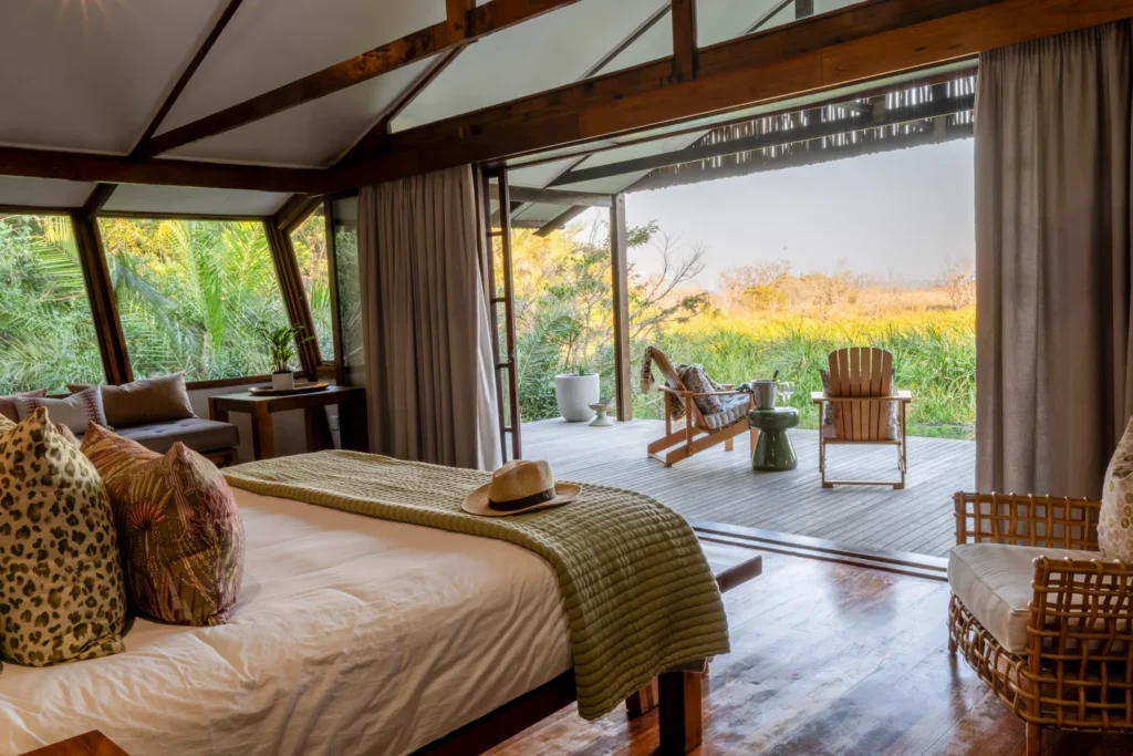 Makakatana Bay Lodge – The honeymoon suite bedroom opens onto a private deck with two chairs facing the wetland.