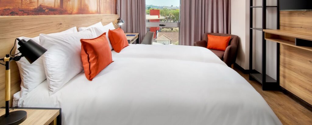 Protea Hotel Pretoria Loftus Park – Guest room with forest mural on wall