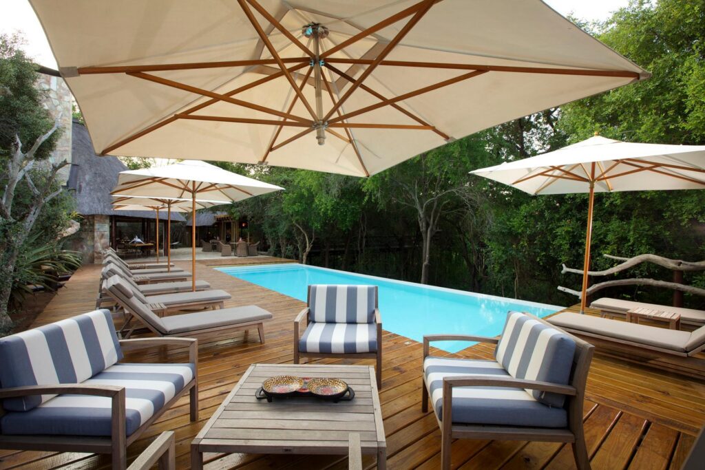 Kapama Buffalo Camp pool deck with umbrellas and loungers