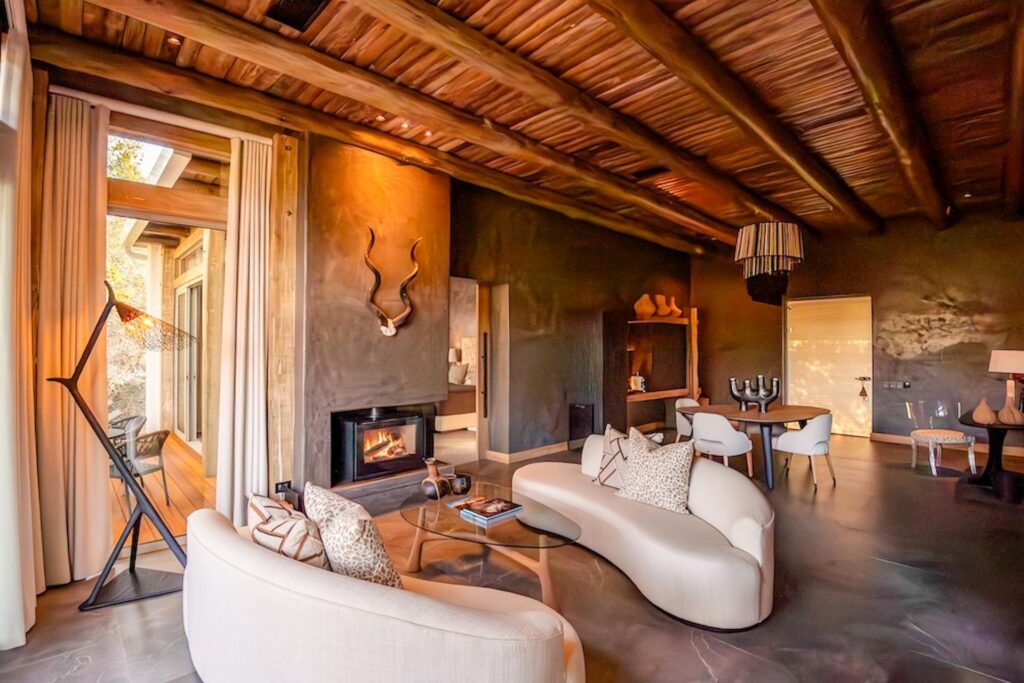 Kapama Karula family villa lounge with curved sofas and a fireplace