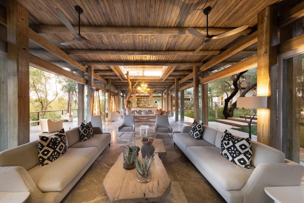Kapama Karula main lounge under a timber roof, with sofas and open sides to the bush