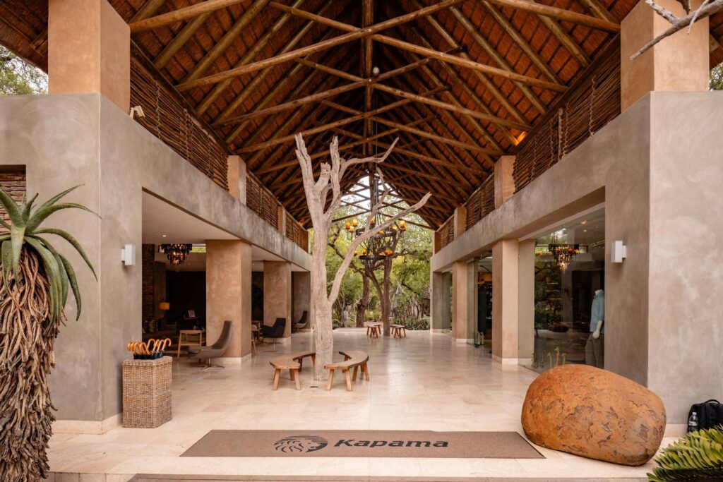 Kapama Southern Camp entrance hall with a thatched roof and a sculpted tree